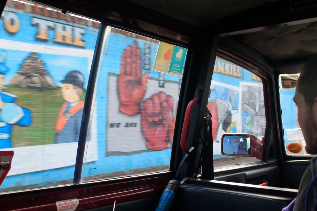 Driving by murals depicting justice movements around the world near the Catholic part of Belfast.
